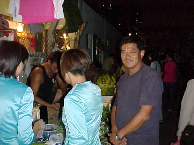 171099-Veg_vendor_at_night_in_Chai_Wan-the_man_in_Navy_T-shirt_owns_a_lot_of_street_counters.JPG (34561 bytes)
